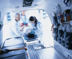 Doctors lifting patient into ambulance
